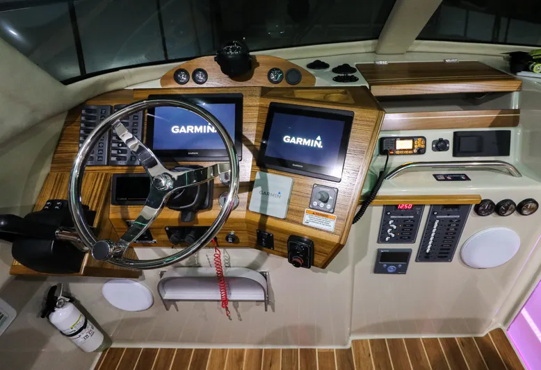  Yacht Photos Pics Aspen C108 2026 boat dashboard with Garmin navigation screens and wooden paneling.