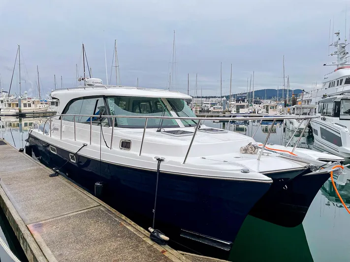 Sojourn Yacht Photos Pics 2022 Aspen C108 yacht docked at a marina, surrounded by other boats.