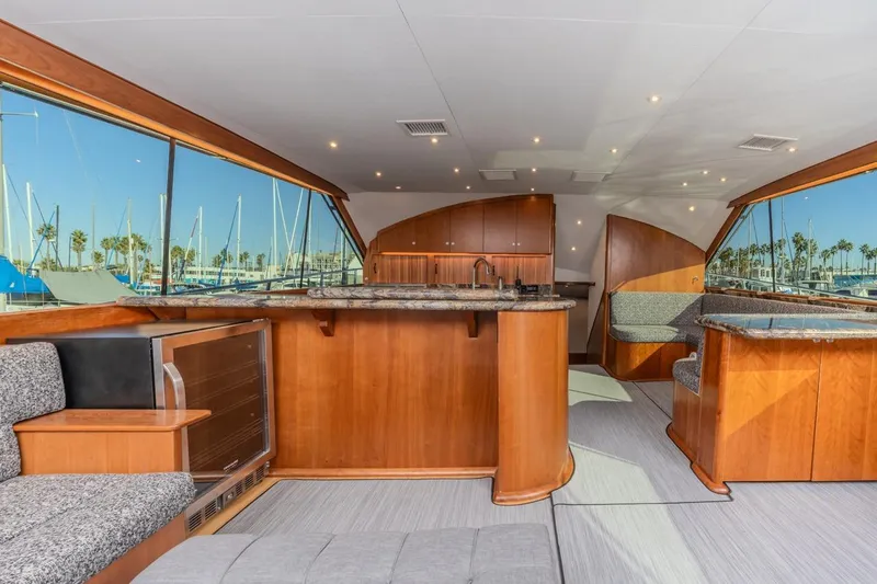 Kolohe Yacht Photos Pics Luxurious interior of 1993 Ocean 65 Custom yacht with elegant wood finishes and marina view.