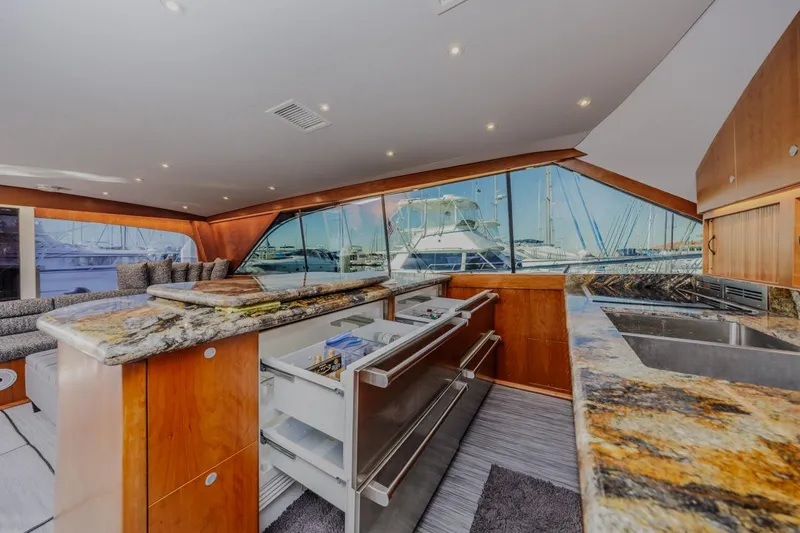 Kolohe Yacht Photos Pics Luxurious interior of 1993 Ocean 65 Custom yacht with granite countertops and marina view.