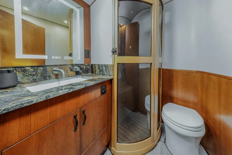 Kolohe Yacht Photos Pics Luxurious bathroom in 1993 Ocean 65 Custom yacht with modern fixtures and wood accents.