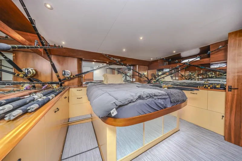 Kolohe Yacht Photos Pics Luxurious 1993 Ocean 65 Custom yacht bedroom with fishing rods and elegant wood finish.