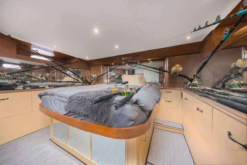 Kolohe Yacht Photos Pics Luxurious 1993 Ocean 65 Custom yacht bedroom with fishing rods and elegant wood cabinetry.
