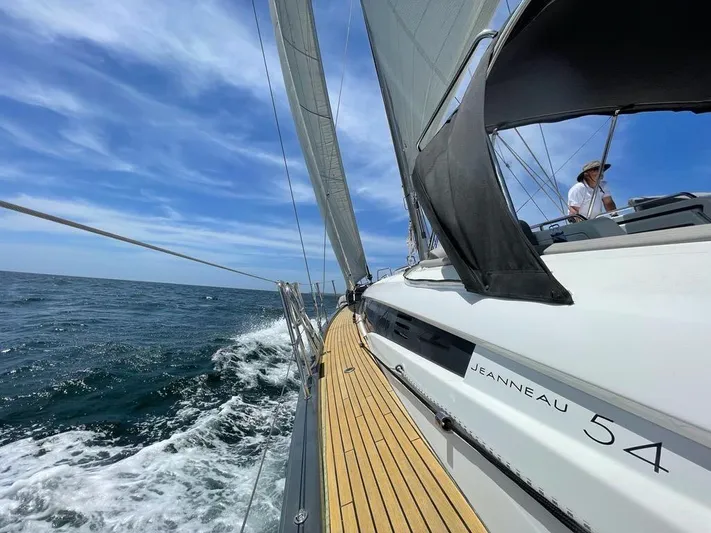 Edwina Yacht Photos Pics Sailing Jeanneau 54 yacht on open sea under clear blue sky, 2018 model.