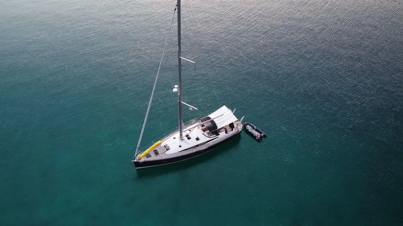 Edwina Yacht Photos Pics Aerial view of 2018 Jeanneau 54 sailboat anchored in calm, clear waters.