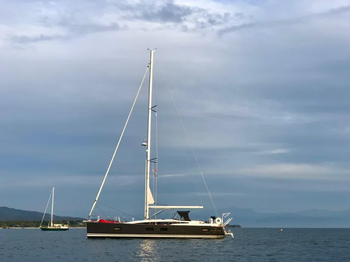 Edwina Yacht Photos Pics 2018 Jeanneau 54 sailboat anchored on calm water under a cloudy sky.