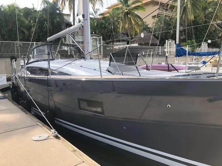 Edwina Yacht Photos Pics 2018 Jeanneau 54 yacht docked, sleek design, palm trees in background.