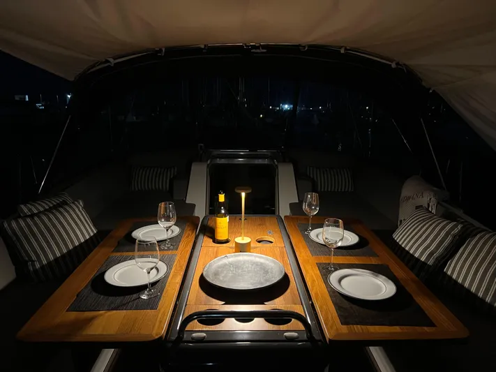 Edwina Yacht Photos Pics Luxurious dining setup on a 2018 Jeanneau 54 yacht at night.