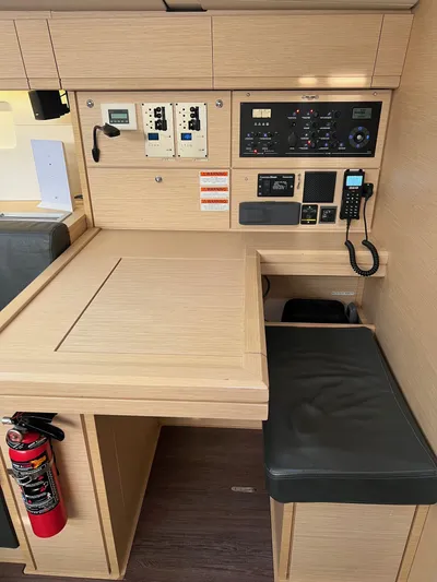 Edwina Yacht Photos Pics Interior view of a 2018 Jeanneau 54 yacht's navigation station with control panels and seating.
