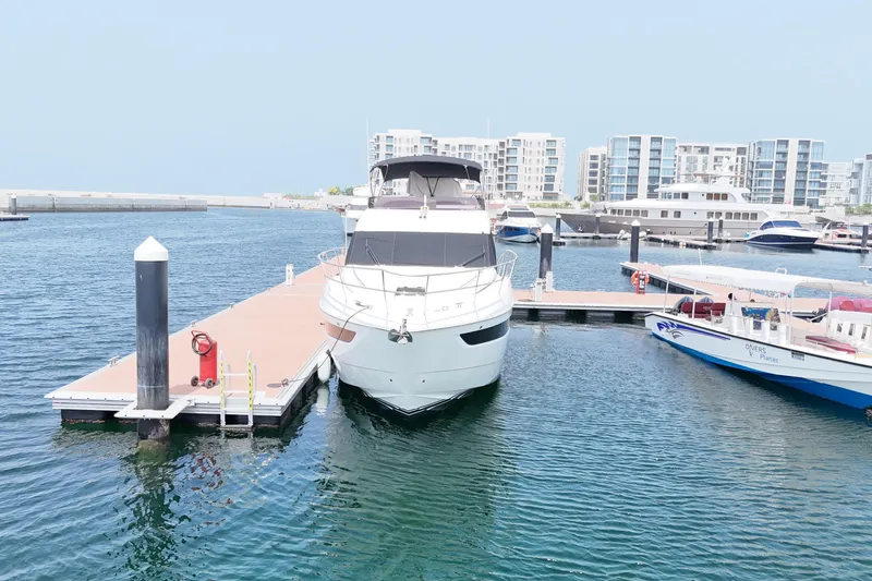  Yacht Photos Pics 2022 Princess F50 yacht docked at a marina with modern buildings in the background.