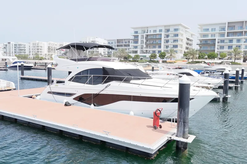  Yacht Photos Pics Luxury 2022 Princess F50 yacht docked at a marina with modern buildings in the background.