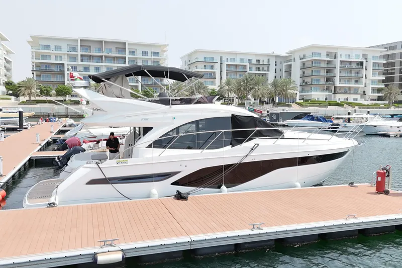  Yacht Photos Pics Luxury 2022 Princess F50 yacht docked at marina with modern buildings in background.