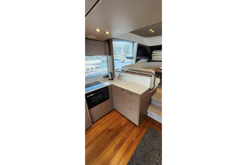  Yacht Photos Pics Modern kitchen interior on 2022 Princess F50 yacht with wood flooring and sleek cabinetry.