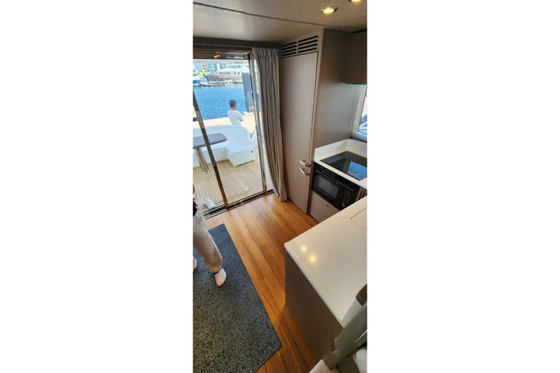  Yacht Photos Pics Interior view of 2022 Princess F50 yacht with modern kitchen and deck access.