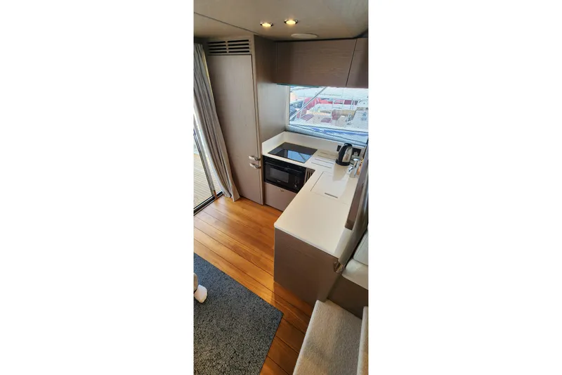  Yacht Photos Pics Modern kitchen interior on 2022 Princess F50 yacht with wood flooring and sleek appliances.