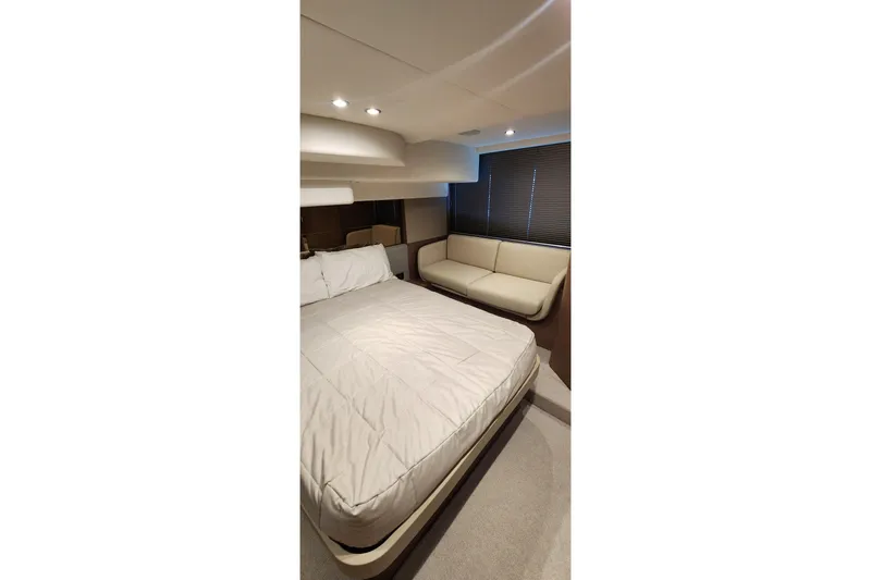  Yacht Photos Pics Luxurious bedroom interior of 2022 Princess F50 yacht with bed and sofa.