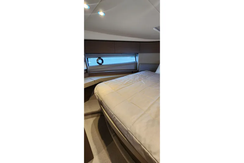  Yacht Photos Pics Luxurious cabin interior of 2022 Princess F50 yacht with cozy bed and window view.