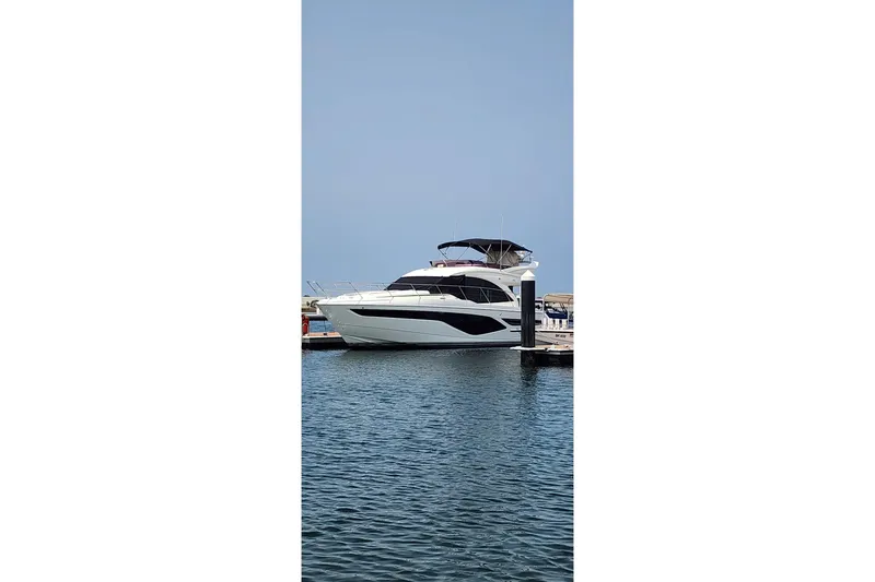  Yacht Photos Pics 2022 Princess F50 yacht docked at marina, calm water, clear sky.