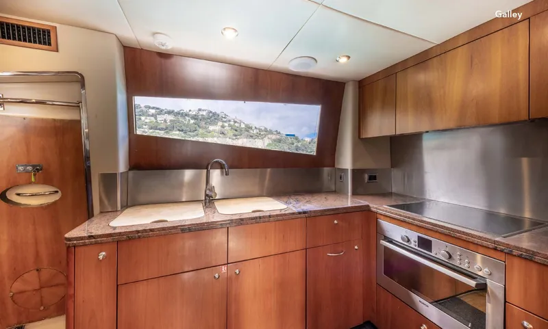  Yacht Photos Pics Luxurious galley kitchen in 2007 Sunseeker 90 Yacht with wood cabinetry and modern appliances.