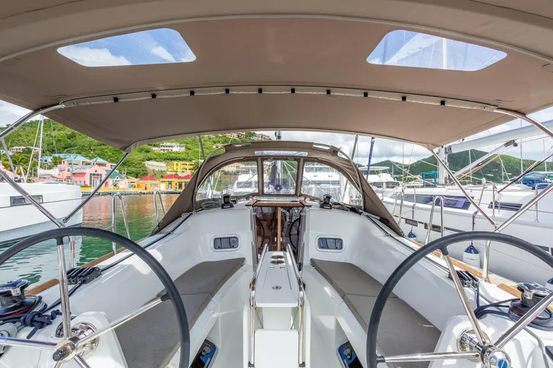 Off The Clock Yacht Photos Pics 2020 Jeanneau Sun Odyssey 349 sailboat cockpit with dual steering wheels, docked in a marina.