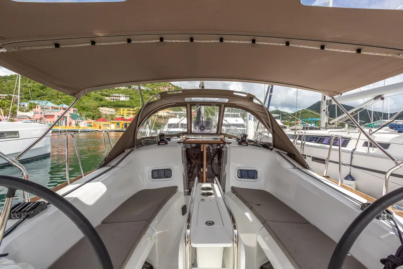 Off The Clock Yacht Photos Pics 2020 Jeanneau Sun Odyssey 349 sailboat cockpit with canopy, docked in a marina.