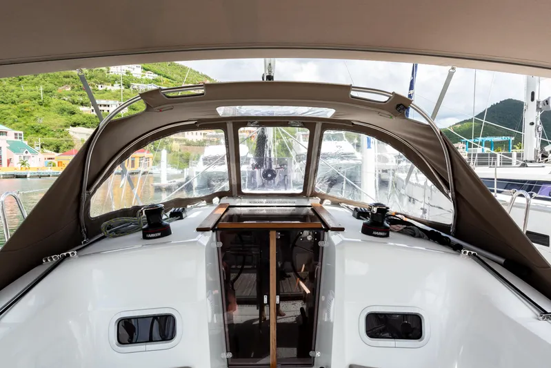 Off The Clock Yacht Photos Pics 2020 Jeanneau Sun Odyssey 349 yacht cockpit with canopy, docked in a scenic marina.