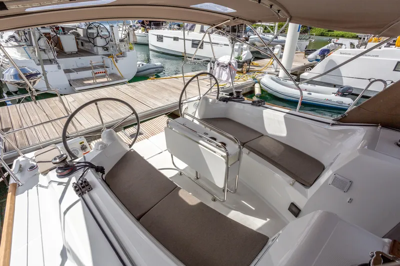Off The Clock Yacht Photos Pics 2020 Jeanneau Sun Odyssey 349 sailboat cockpit with dual steering wheels at marina.