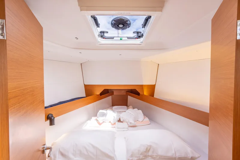 Off The Clock Yacht Photos Pics Cozy cabin interior of 2020 Jeanneau Sun Odyssey 349 sailboat with skylight and bed.