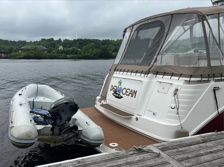  Yacht Photos Pics 2006 Rinker 390 Express Cruiser docked with inflatable dinghy on calm water.