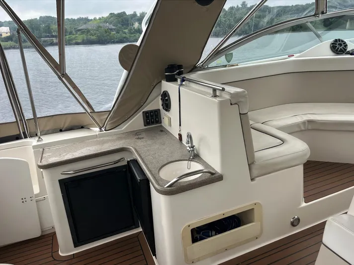  Yacht Photos Pics 2006 Rinker 390 Express Cruiser interior with sink, mini-fridge, and seating area.