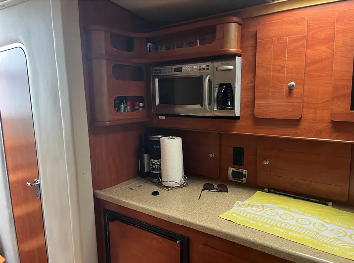  Yacht Photos Pics 2006 Rinker 390 Express Cruiser kitchen with microwave, countertop, and wooden cabinets.