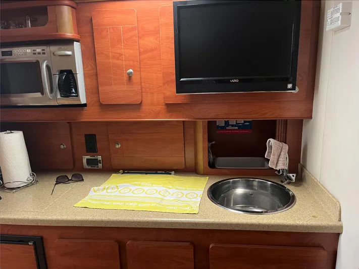  Yacht Photos Pics 2006 Rinker 390 Express Cruiser kitchen with microwave, TV, sink, and countertop.