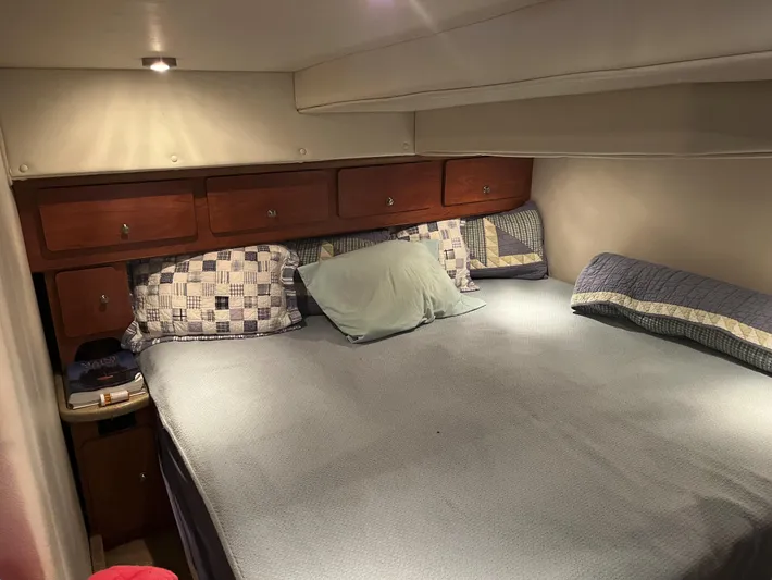  Yacht Photos Pics 2006 Rinker 390 Express Cruiser cabin with bed, wooden cabinets, and soft lighting.