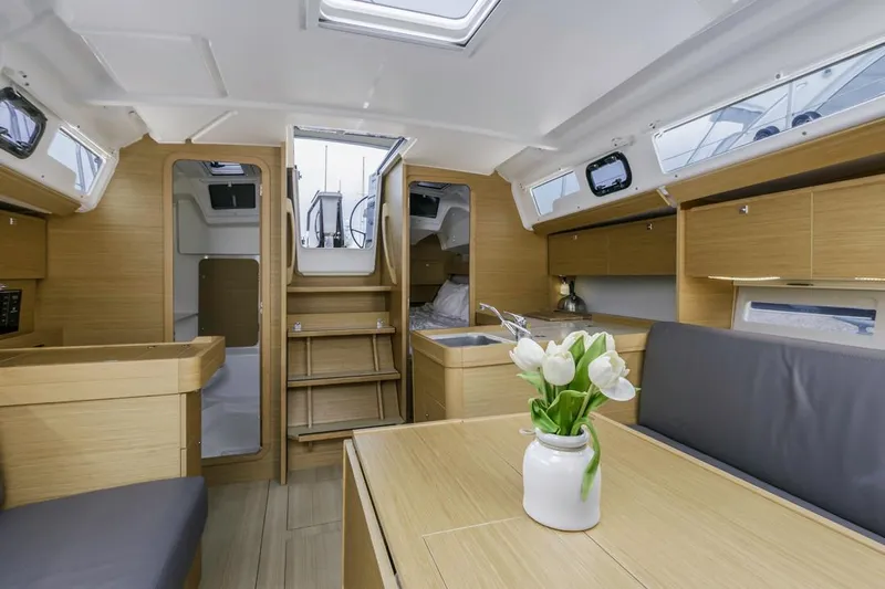 Dotwick Jinga Yacht Photos Pics Modern interior of 2020 Dufour 360 yacht with wooden finish and tulip centerpiece.