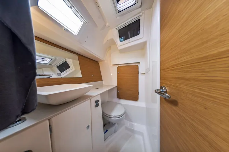 Dotwick Jinga Yacht Photos Pics Modern bathroom interior of 2020 Dufour 360 yacht, featuring sleek design and wooden accents.