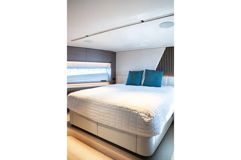  Yacht Photos Pics Luxurious bedroom interior of 2023 Princess Y72 yacht with modern design and blue accents.