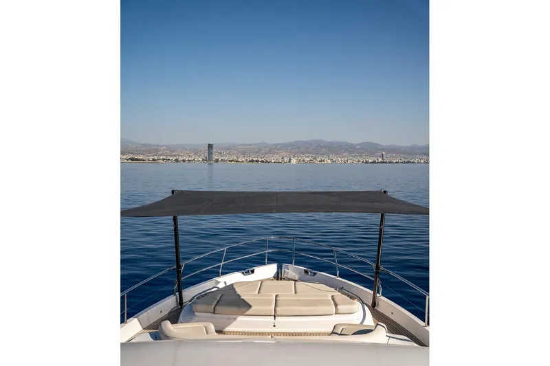  Yacht Photos Pics Luxury yacht Princess Y72, 2023 model, cruising with cityscape and mountains in the background.