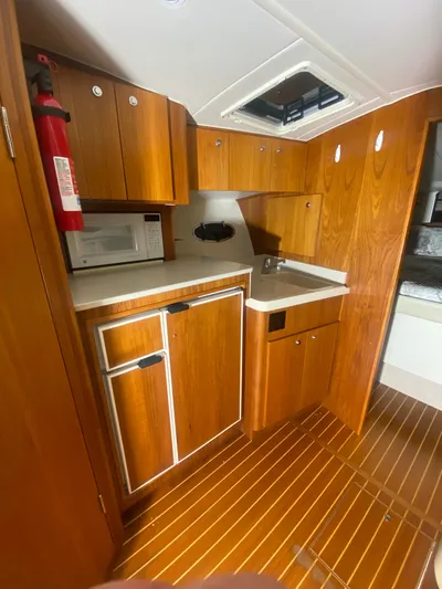 Details Yacht Photos Pics 1998 Tiara Yachts 35 Open galley with wood cabinetry, sink, and microwave.