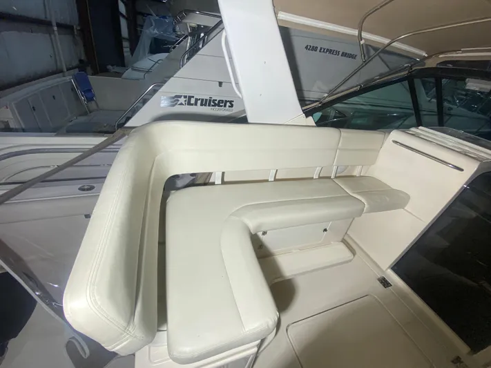 Details Yacht Photos Pics 1998 Tiara Yachts 35 Open interior seating with white upholstery in a boat showroom.