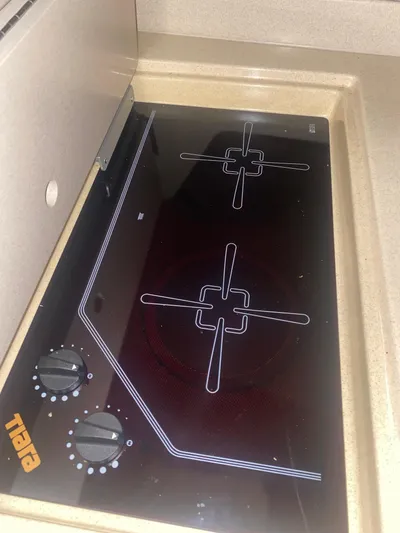 Details Yacht Photos Pics Built-in stovetop on a 1998 Tiara Yachts 35 Open, featuring two burners and control knobs.