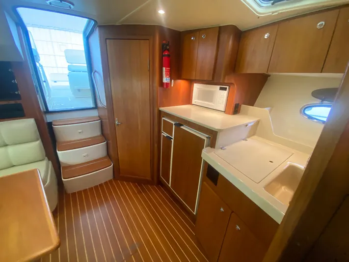 Details Yacht Photos Pics Interior of 1998 Tiara Yachts 35 Open, featuring wood cabinetry and compact kitchen area.