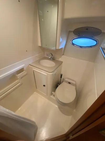 Details Yacht Photos Pics 1998 Tiara Yachts 35 Open bathroom with sink, toilet, and porthole window.