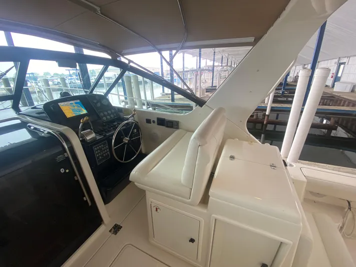 Details Yacht Photos Pics 1998 Tiara Yachts 35 Open helm with navigation equipment and seating in a marina setting.
