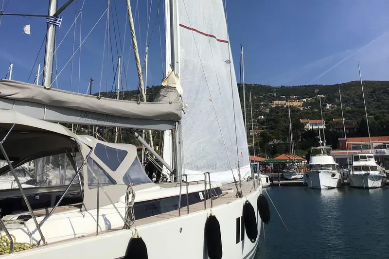  Yacht Photos Pics Sailing yacht Hanse 545, 2010 model, docked in a scenic marina with hills in the background.