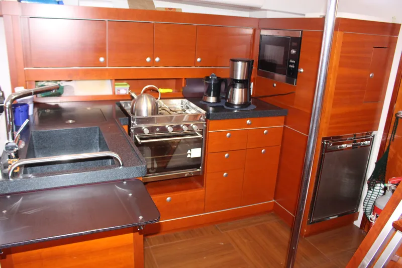  Yacht Photos Pics Luxurious 2010 Hanse 545 yacht kitchen with modern appliances and wooden cabinetry.