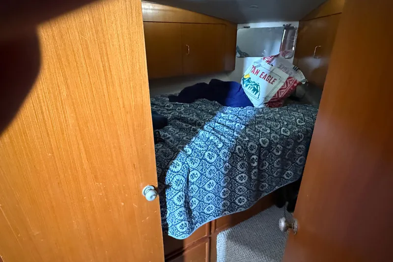  Yacht Photos Pics 1999 Ocean Yachts 40 Express cabin with blue patterned bedding and wooden cabinetry.