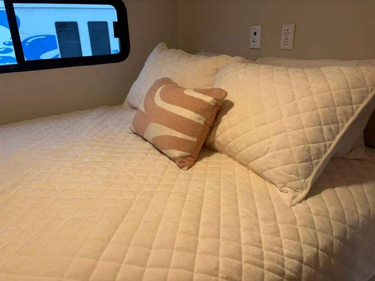Cozy bedroom in 1992 Lakeview houseboat with quilted bedding and decorative pillows.