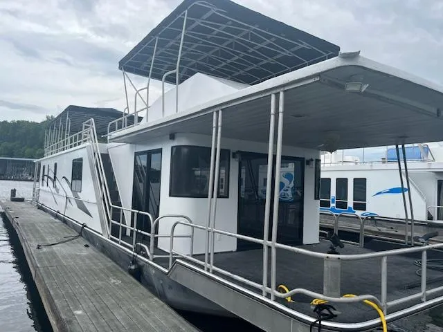 1992 Lakeview houseboat docked, featuring upper deck and covered patio area.
