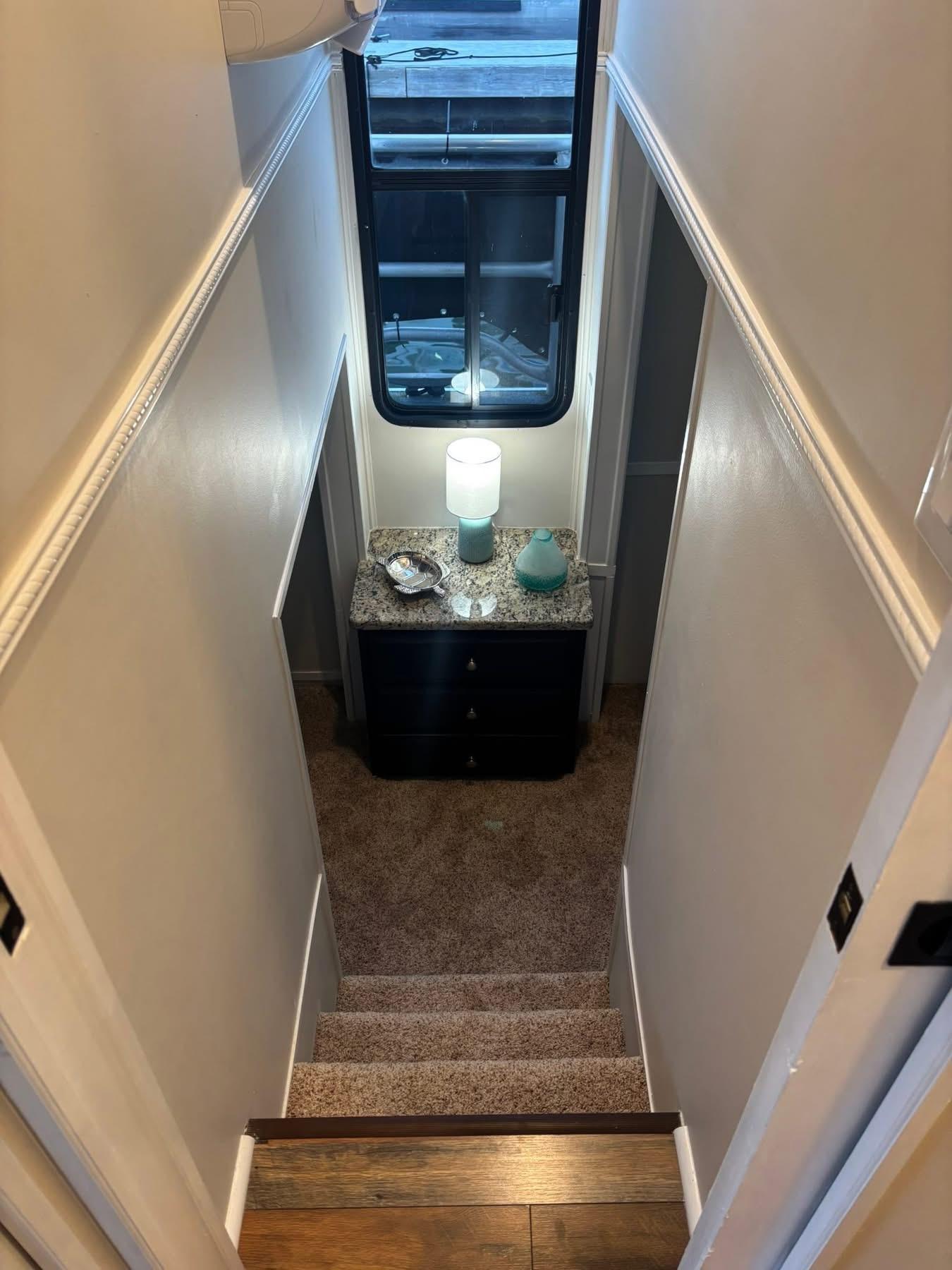 Narrow stairway in 1992 Lakeview houseboat with carpet and decorative table.