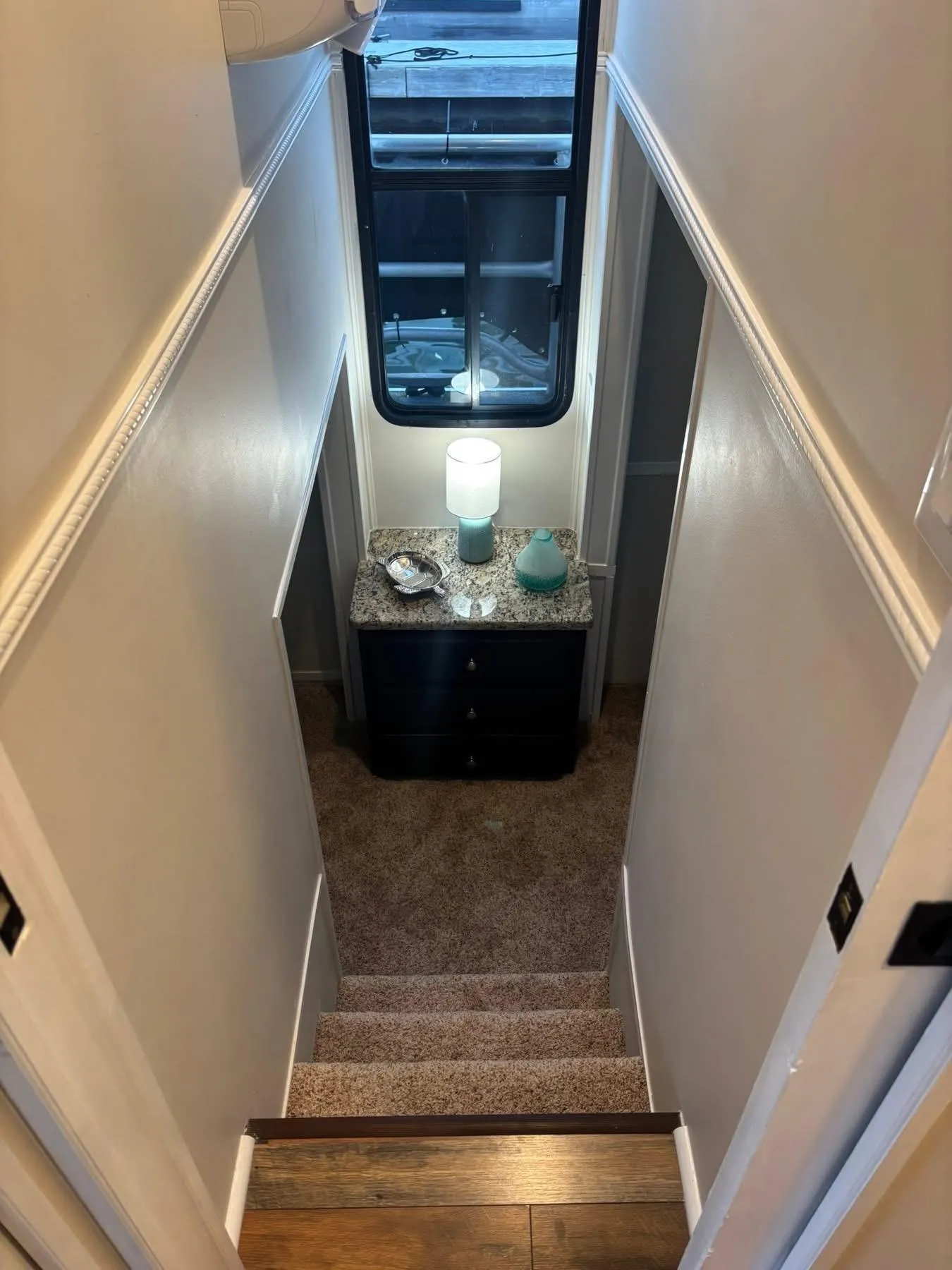 Narrow stairway in 1992 Lakeview houseboat with carpet and decorative table.